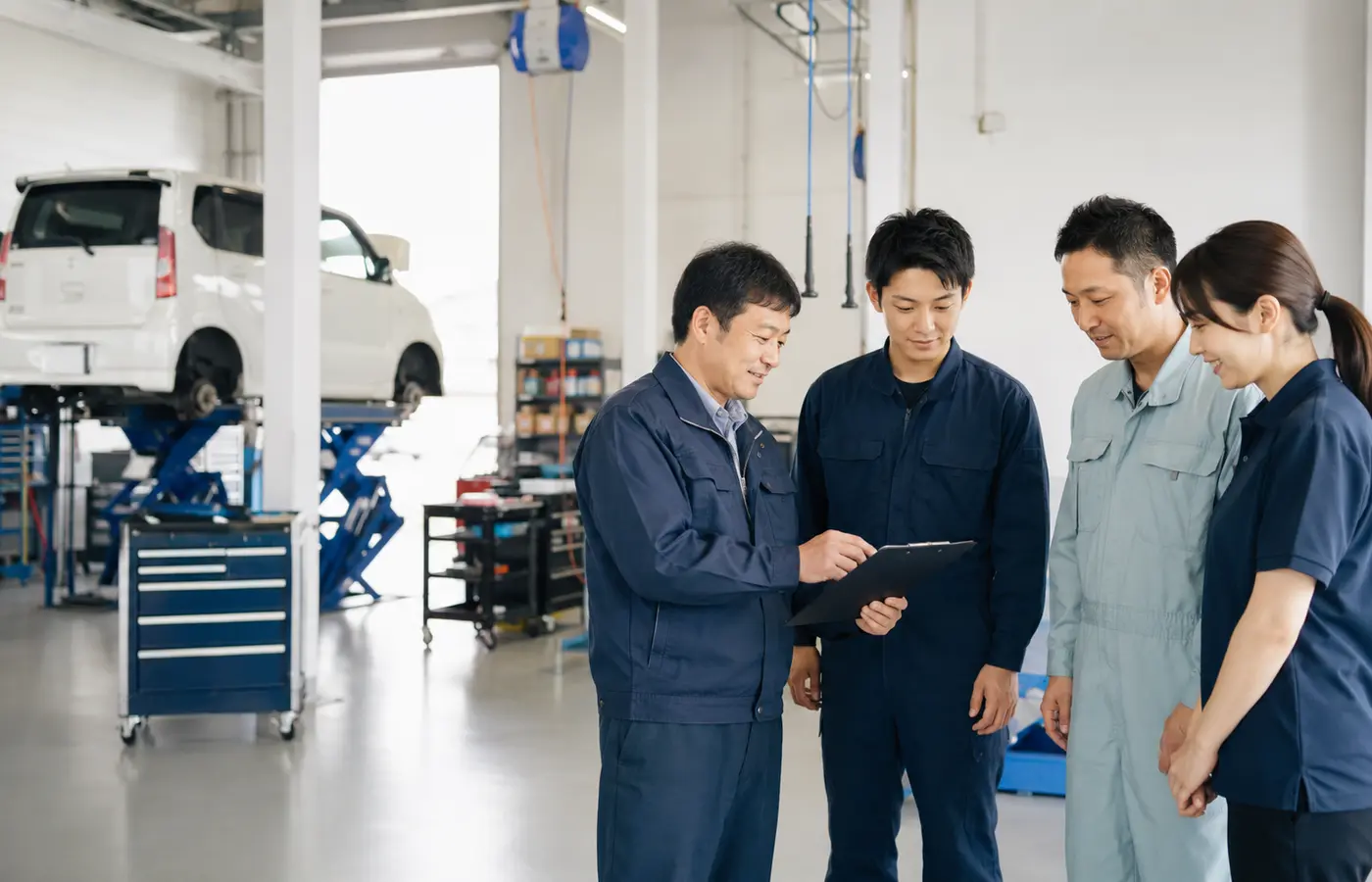 整備工場で打ち合わせをするスタッフチーム